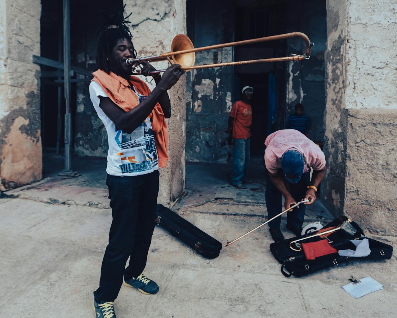 A street musician passionately playing the trombone in an urban setting.